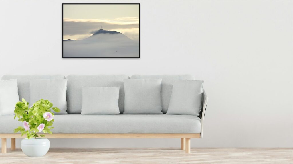 Le puy de Dôme sur une mer de nuages, en affiche encadrée 100 × 70 cm au-dessus d’un canapé (mise en situation)