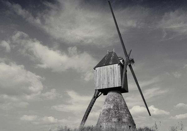 Entre ciel pâle et pierre nue, tableau moulin à vent en noir et blanc