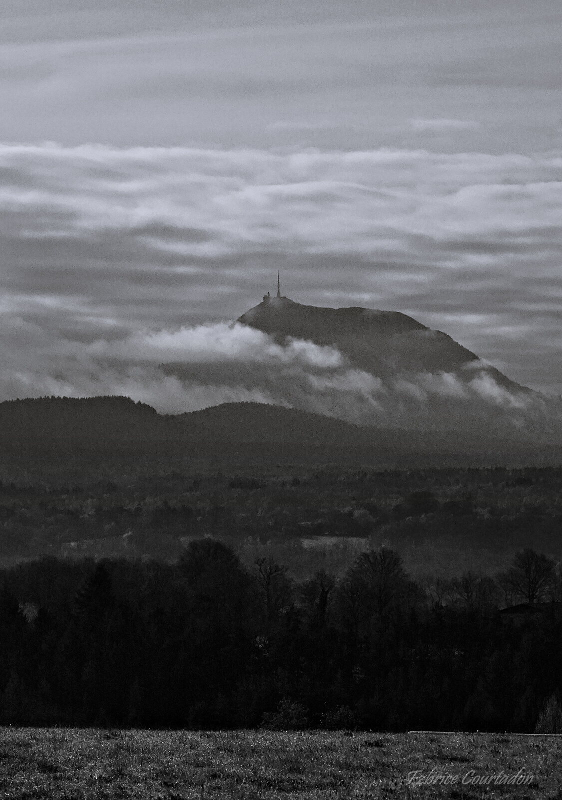 Le puy de Dôme dans un voile de nuages, photographie sur toile ou en affiche encadrée, aperçu dans un intérieur